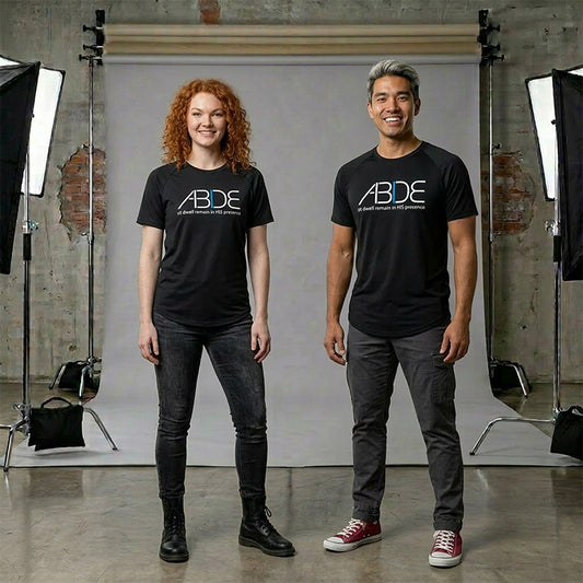 Two people wearing black t-shirts with 'ABDE' logo in a studio setting.
