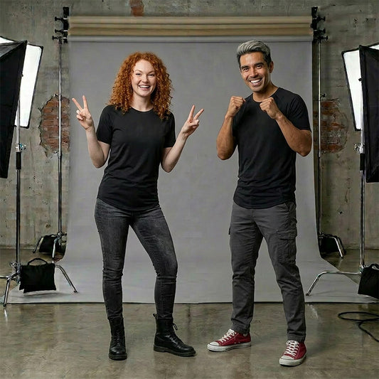 Two people wearing black bamboo tshirt posing in a photo studio with professional lighting equipment.