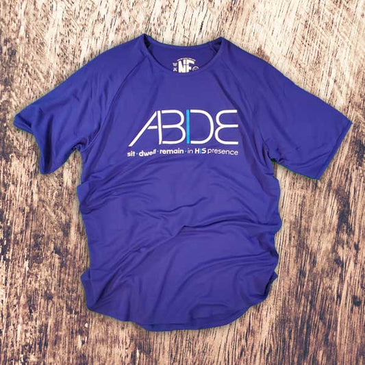 Blue ABIDE Bamboo Christian Tee on a wooden surface