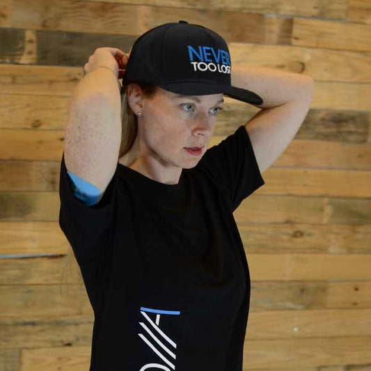 Christian Woman wearing a black 'Never Too Lost' cap and Adonai t-shirt with text against a wooden background