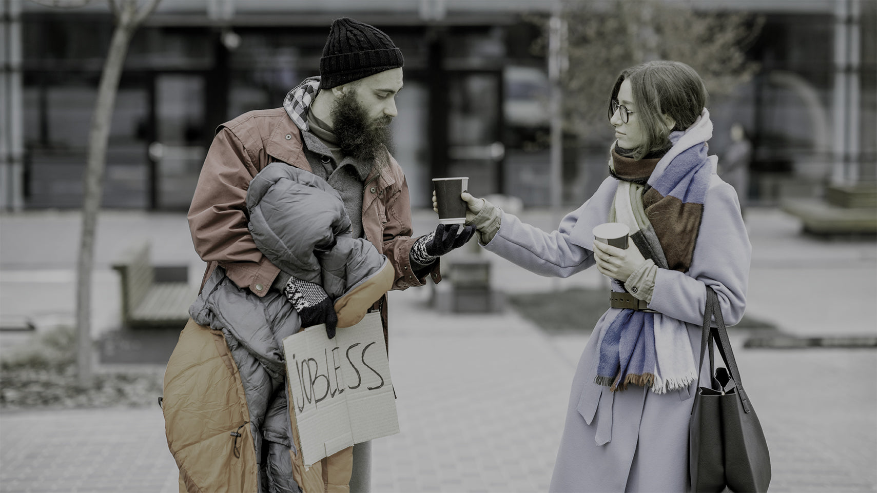 homeless beggar receiving a cup of coffee from a generous caring Christian woman