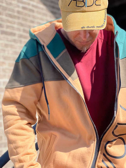 Steve Cohen is pictured wearing a Now Found Apparel Adonai zip-up adonai wine red bamboo tee and an Abide hat.