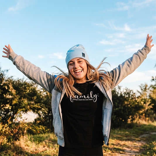 beautiful christian female youth wearing blue "i am" beanie and zip-up hoodie with a "family" bamboo tee from now found apparel.