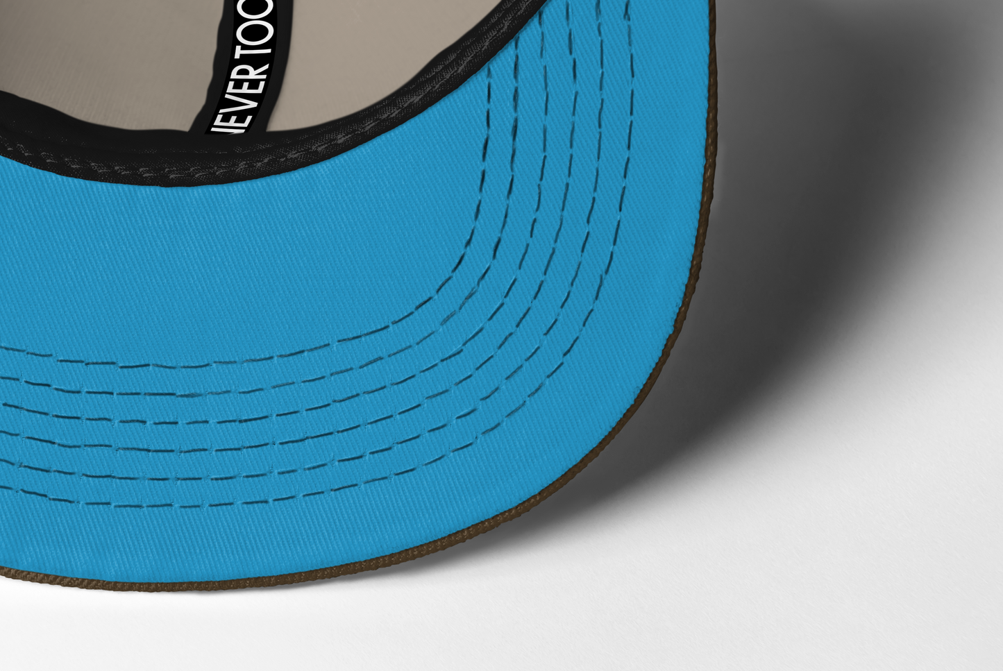 Close-up of blue under bill of ball cap with visible stitching on a white background