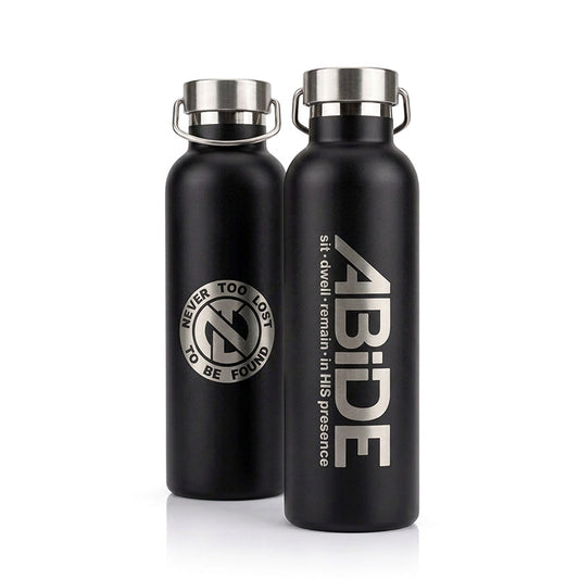 Two black Water Bottles with stainless steel screw on lid with handle, the one in front showing a laser engraved ABiDE sit - dwell - remain in HIS presence logo and the rear showing the back of the bottle with the signature Never Too Lost 'NTL' Logo with Never Too Lost To Be Found encircled around it.