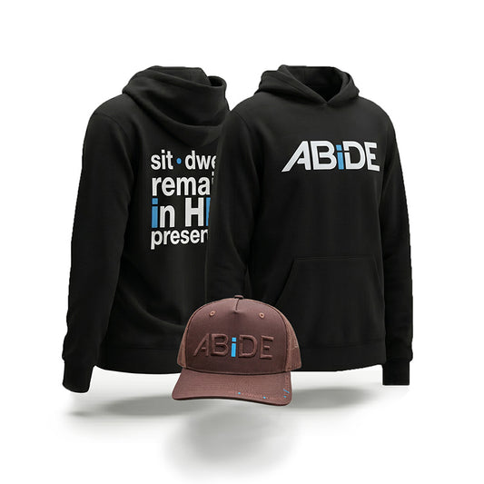 Black hoodie and Brown Trucker Hatt with 'ABiDE' branding and 'sit dwell remain in HIS presence' on the bill and back on a white background