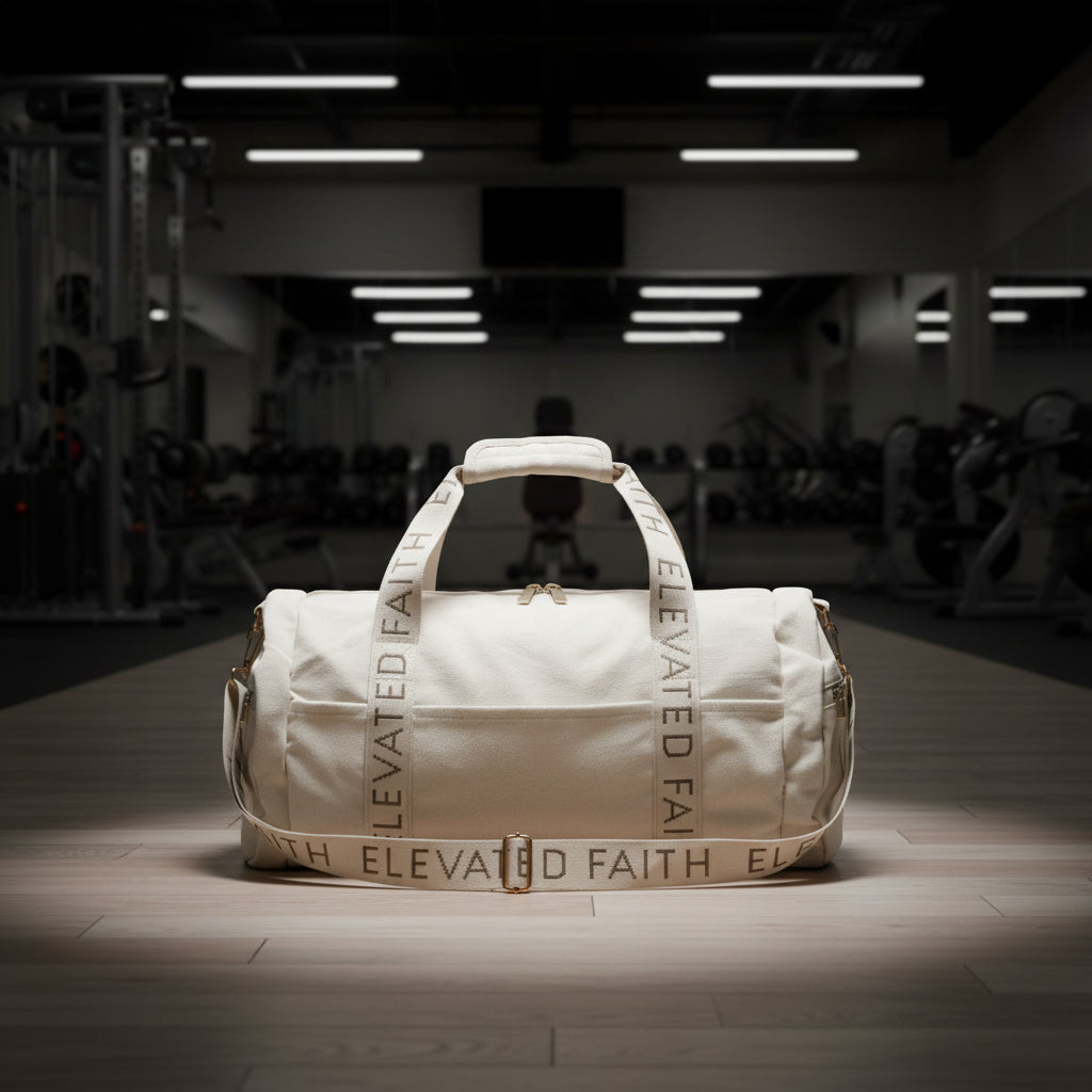 Beige duffel bag with 'Elevated Faith' branding on gym floor