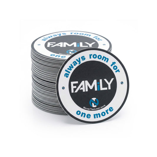 A stack of round black and white vinyl stickers with blue and white text reading 'FAMILY - always room for one more' on a clean white background.