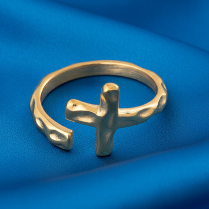 Gold ring with a cross design on a white background