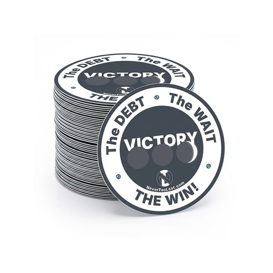 A stack of round dark grey and white Victory Collection stickers with one sticker in front showing the text 'VICTORY THE DEBT • THE WAIT • THE WIN!' with a 3 days in the grave circle design and a small NeverTooLost.com logo.