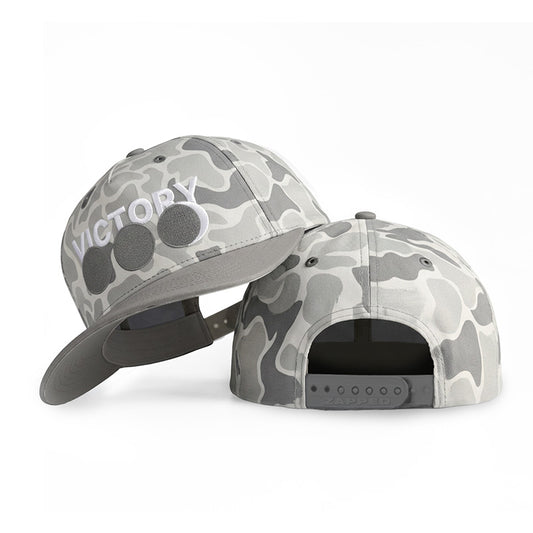 Two gray and white camouflage baseball caps shown on a clean white background, one from the front showing a 'VICTORY' logo, and one from the back showing the snapback closure.